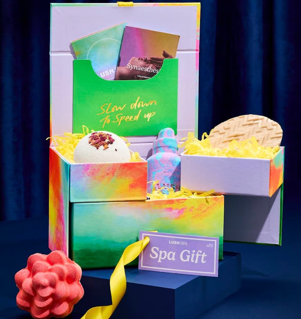 A vibrant gift box containing a gift card and a wrapped present, symbolizing celebration and generosity.