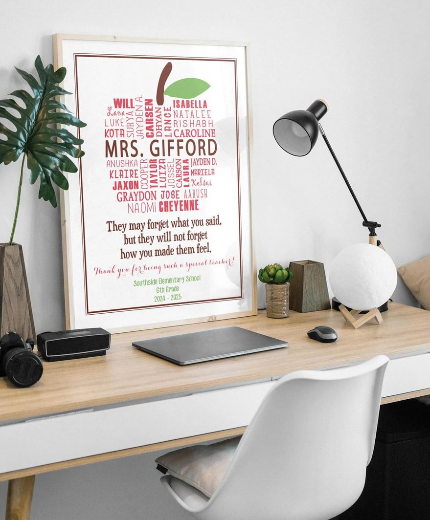 Desk with framed teacher appreciation poster, laptop, and lamp