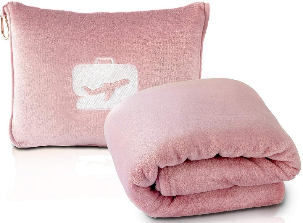 A pink blanket spread out with a suitcase resting on top, suggesting a travel or packing scenario.