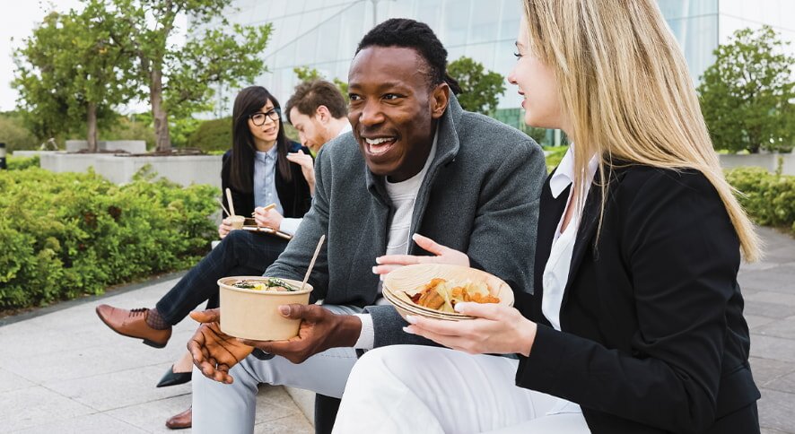 Colleagues eating lunch outside office building