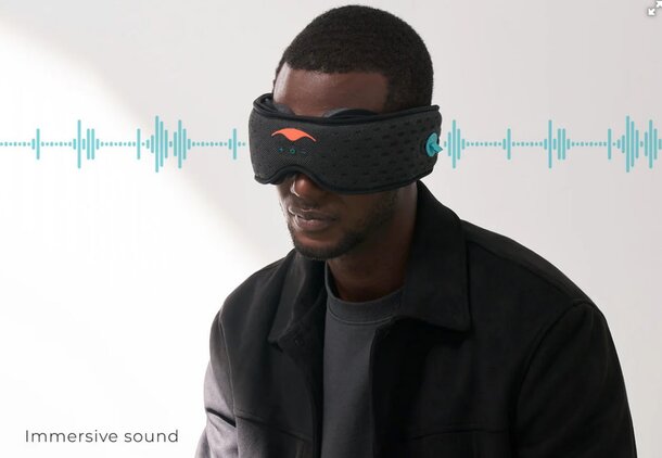 A man wearing an eye mask with sound waves emanating from it, suggesting a focus on relaxation or meditation.