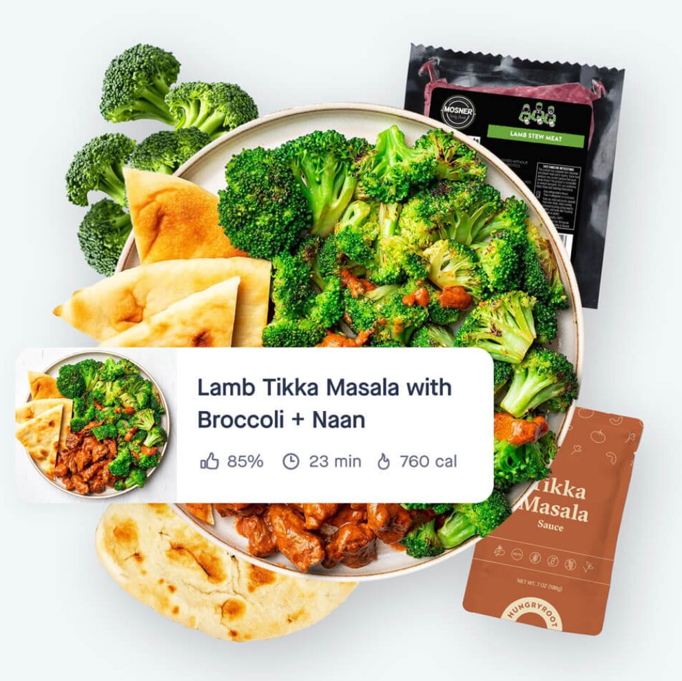 A bowl of vibrant lamb tikka masala topped with bright green broccoli and served with naan bread. Text overlay shows "85% like," "23 mins," "760 cal."