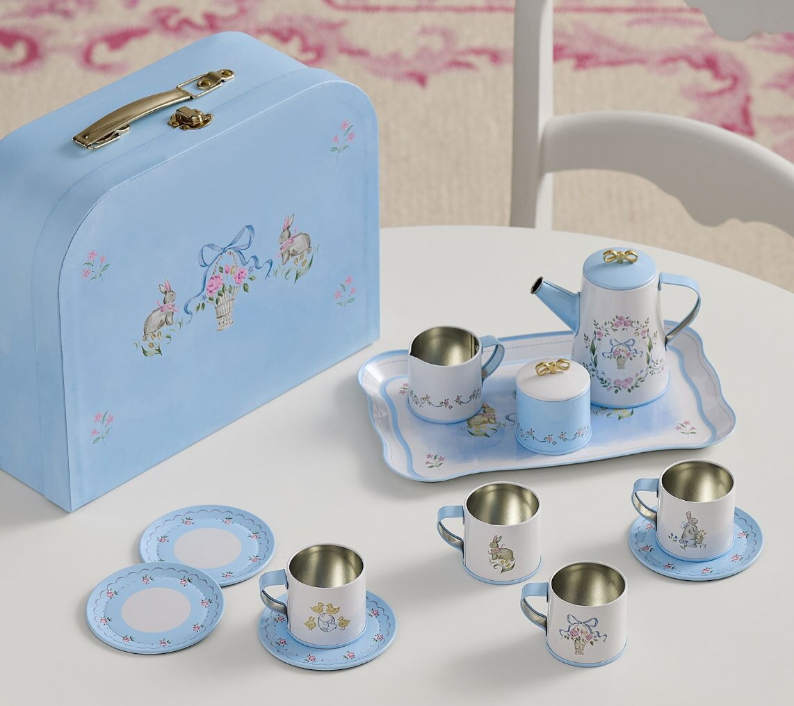 A blue suitcase containing a tea set with cups arranged neatly inside.