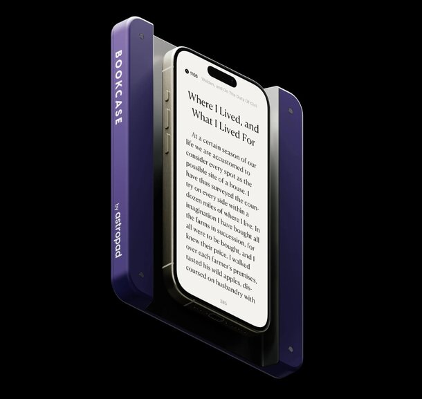 A purple phone with a book resting on its screen, showcasing a blend of technology and literature.