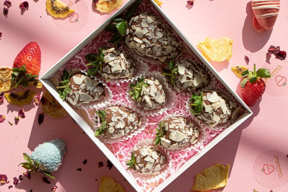 A box filled with fresh strawberries and chocolate-covered strawberries, showcasing a delightful assortment of treats.