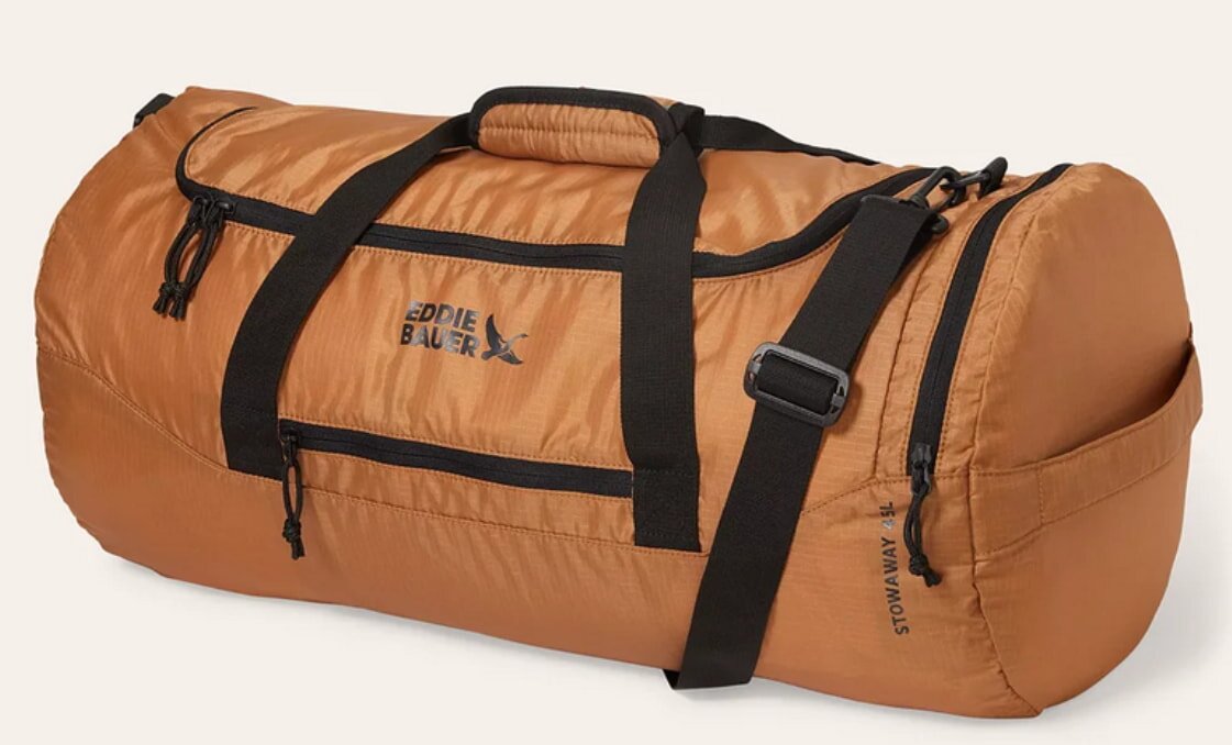 Tan North Face duffel bag displayed against a neutral background, showcasing its durable design and spacious interior.