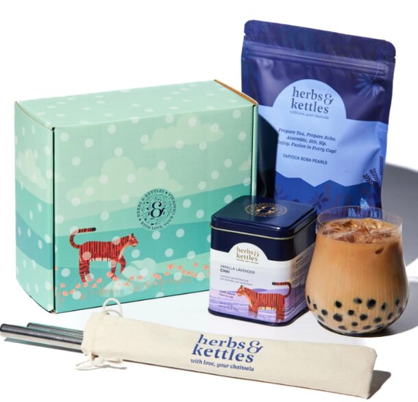 A lunch box containing a fresh salad, a fork, a spoon, and various utensils arranged neatly inside.