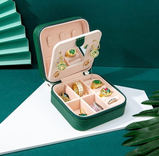 A green jewelry case featuring a green and gold design, elegantly showcasing its luxurious appearance.