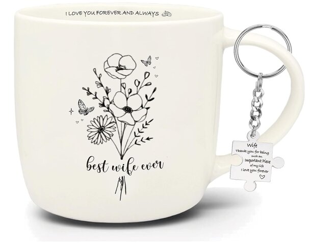 A ceramic mug featuring a floral design alongside a colorful keychain resting on a wooden surface.
