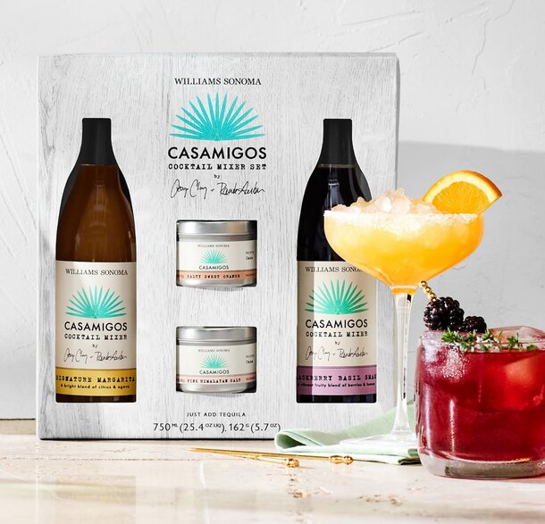 A bottle of Cayamos cocktail and two bottles of Cayamos liqueur displayed together on a wooden surface.