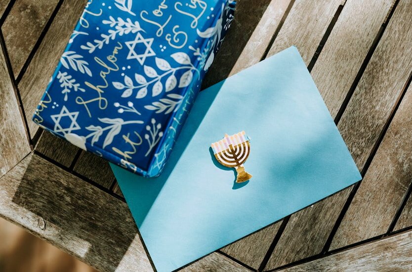 Hanukkah menorah displayed on blue paper featuring a blue and white patterned background.