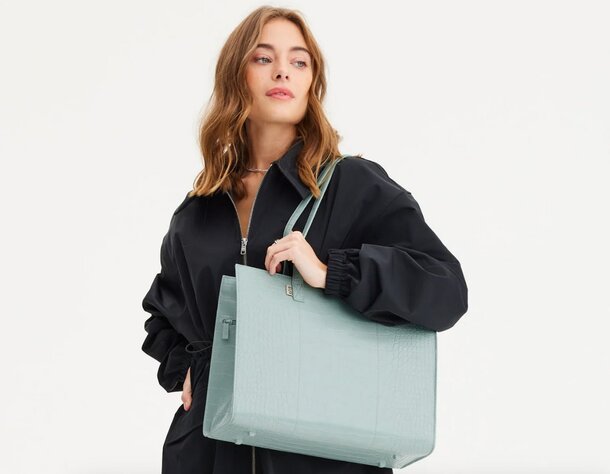 A large tote bag in mint green, featuring a spacious interior and sturdy handles for easy carrying.