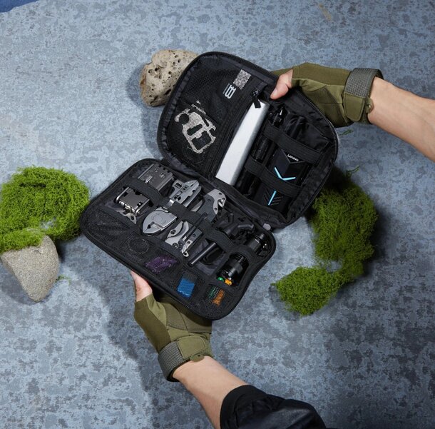 A person holding a small case containing a camera and various accessories, showcasing their photography gear.
