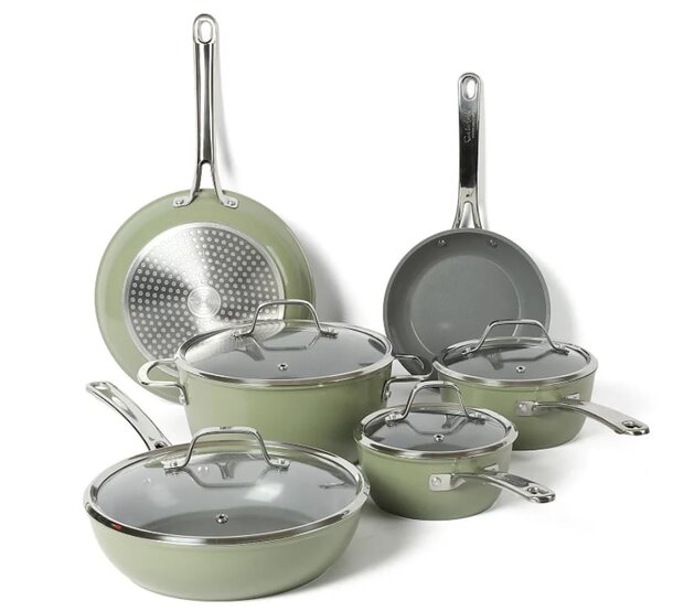 A green cookware set featuring various pans and matching lids arranged neatly on a countertop.
