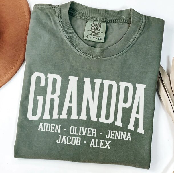 A green shirt featuring the word "Grandpa" displayed prominently, accompanied by a matching hat.