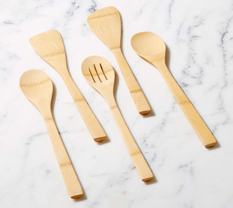 Set of wooden kitchen utensils on marble surface