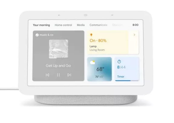Google Home Mini, a small smart speaker, designed for voice commands and home automation, sits on a wooden table.  