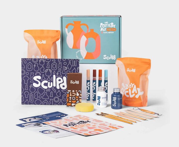 A box filled with various items, including a pen, several pencils, and an additional smaller box.