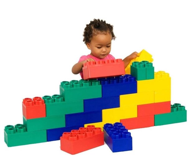A young girl joyfully stacking colorful blocks, showcasing her creativity and playfulness in a bright environment.