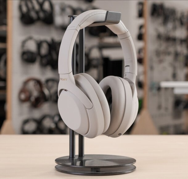 A pair of headphones displayed on a stand in a retail store setting.