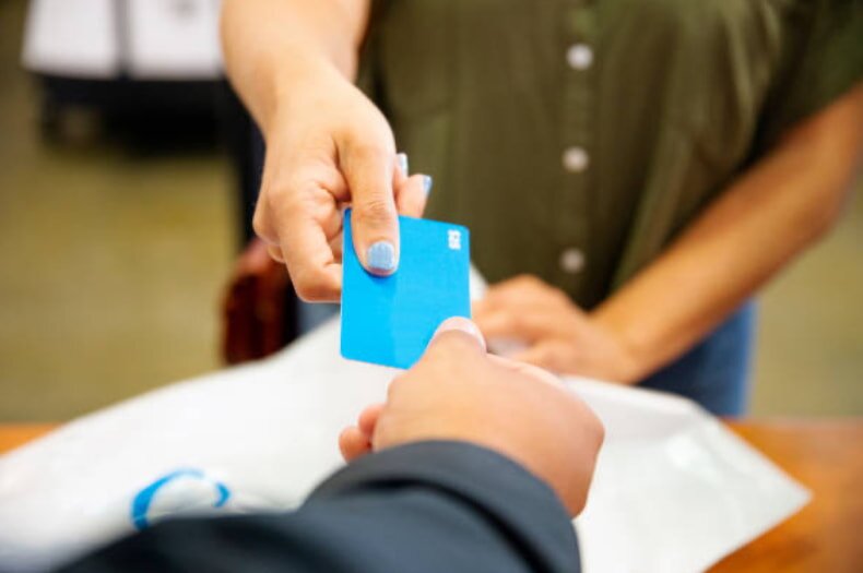 One individual is passing a credit card to another, indicating a payment exchange.