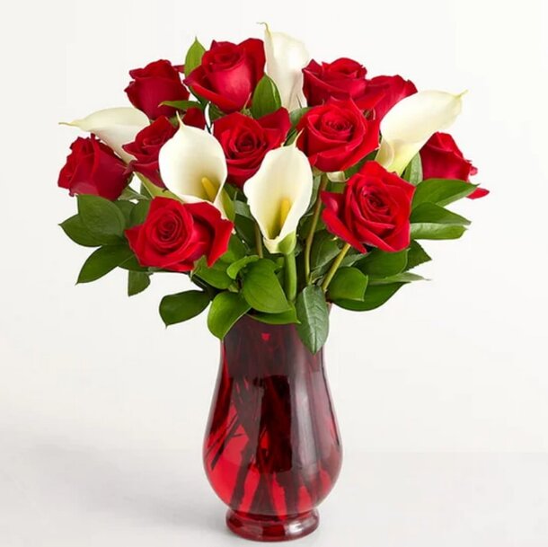 A red vase filled with white and red roses, showcasing a vibrant floral arrangement.