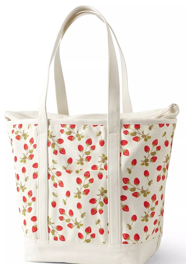 A white tote bag adorned with vibrant red strawberries, showcasing a playful design.