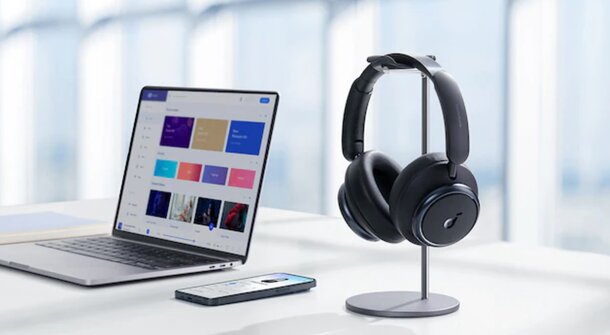 A laptop and a pair of headphones are placed on a wooden desk, suggesting a workspace for study or music.