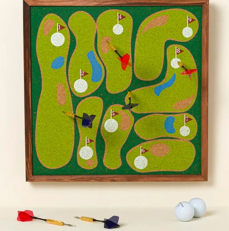 A golf-themed board game featuring darts and golf balls, showcasing a colorful game layout and various playing pieces.