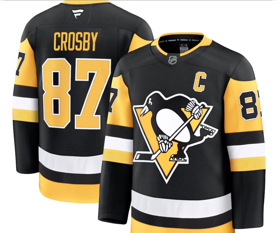 Black and yellow hockey jersey, featuring a penguin logo on the front. Number 87 and letter "C" are prominent. Name visible on the back.