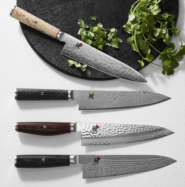 Three knives displayed, each featuring a unique design, showcasing different styles and craftsmanship.