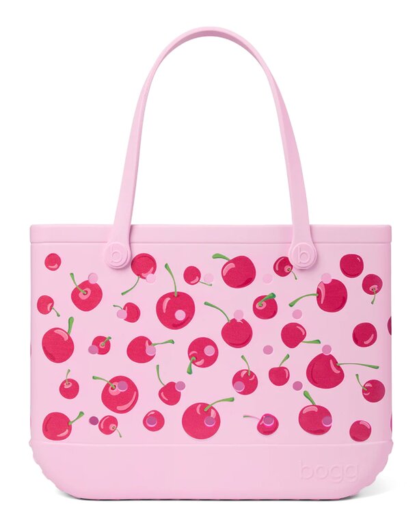 A pink tote bag featuring a pattern of cherries, showcasing a vibrant and playful design.