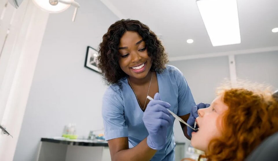 Dentist examining patient's teeth with dental tool