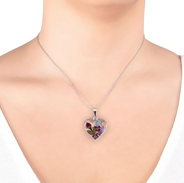 A woman wearing a necklace featuring a heart-shaped pendant, showcasing elegance and personal style.