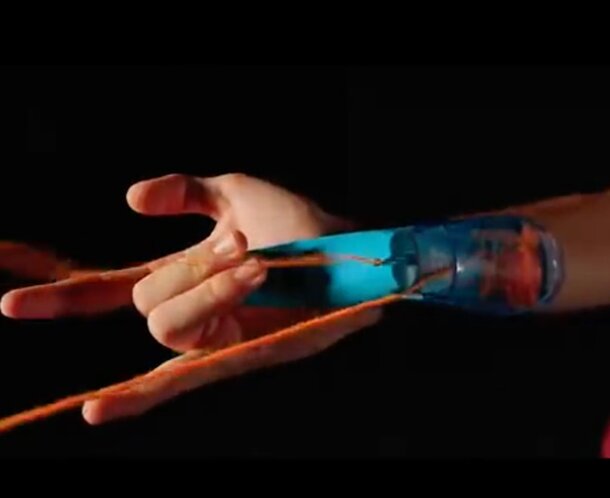 A person holds a string of orange and blue yarn, showcasing the vibrant colors intertwined in their hands.