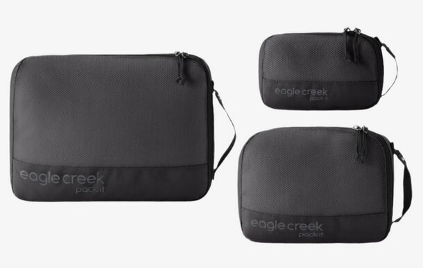 Three distinct black travel bags, each a different size, positioned next to one another.