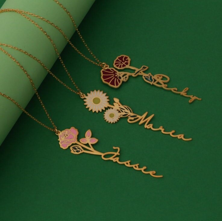 Three gold-plated necklaces featuring floral designs and personalized names.