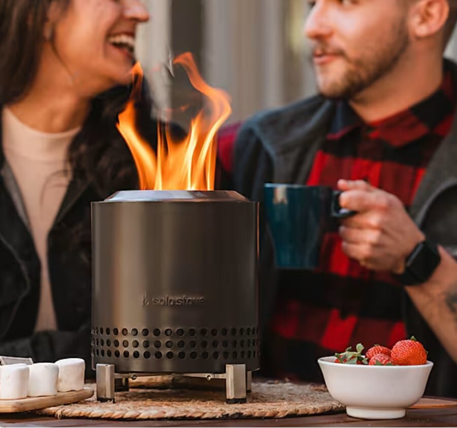 Solo Stove Mesa XL stainless steel tabletop fire pit burning on a patio table.