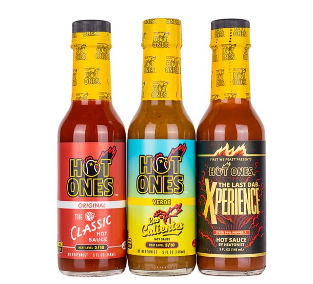 A gift set featuring various bottles of Hot Ones hot sauce, arranged in a stylish box with vibrant labels.