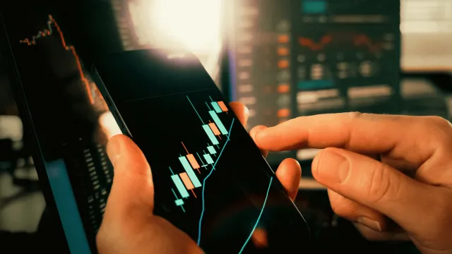 Un investisseur analyse les fluctuations des marchés financiers sur une application mobile