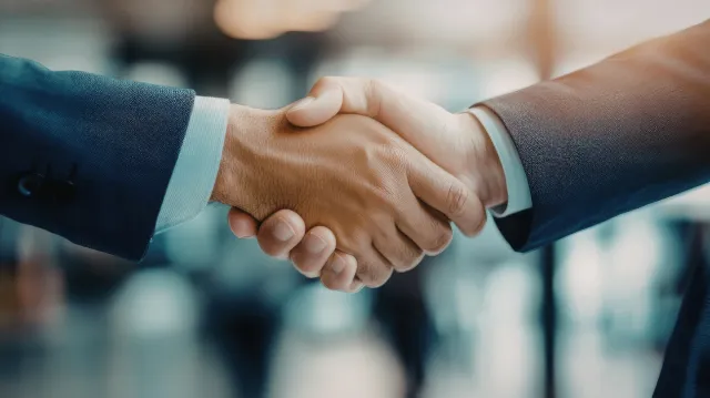 Two business professionals shaking hands, symbolizing partnership and mutual agreement.