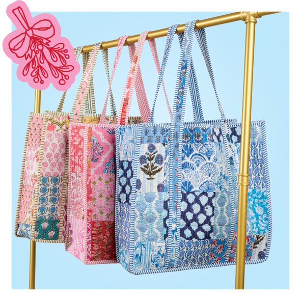 Four quilted bags hanging up on a gold clothing rack