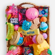 Woven basket filled with colorful sensory toys, squishies, fidget toys, and playful stocking stuffers.