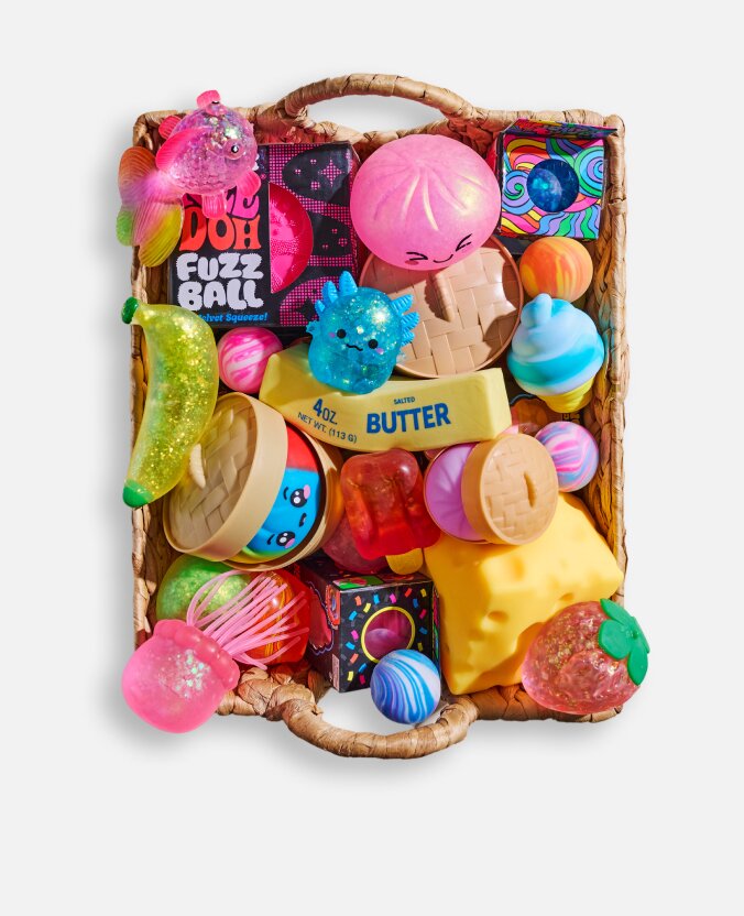 Woven basket filled with colorful sensory toys, squishies, fidget toys, and playful stocking stuffers.