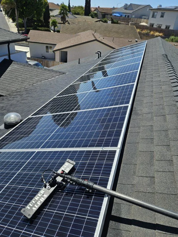 Solar panel cleaning equipment on a residential roof