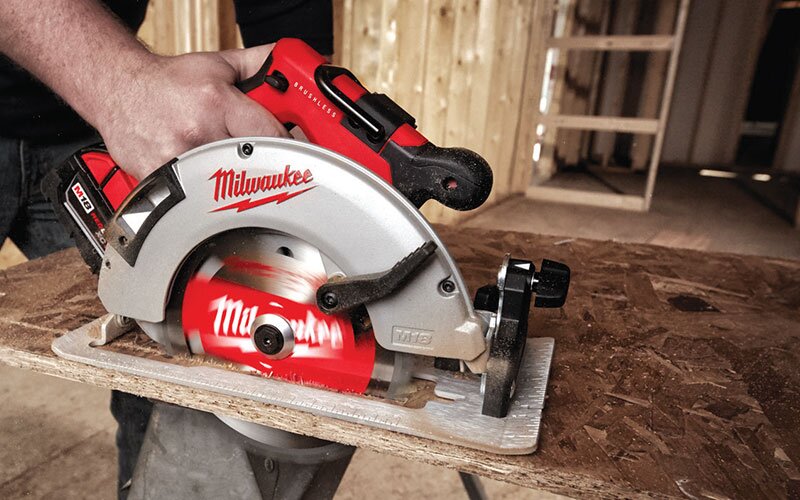 A Milwaukee cordless power saw is being used to cut plywood.