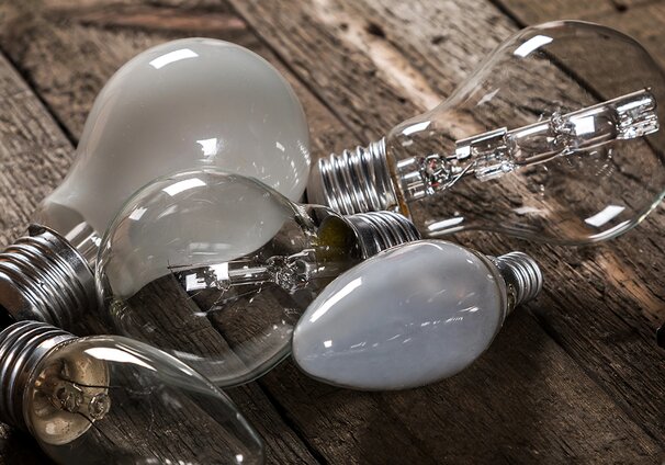 A variety of lightbulbs on a wooden surface.
