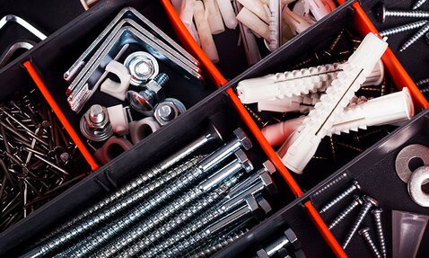 A variety of fasteners and hardware are separated in an organizer.