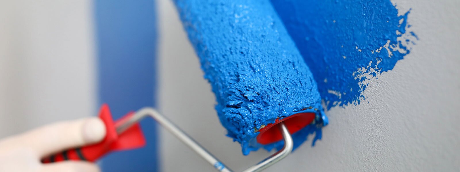 A paint roller painting with blue paint.