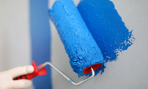 A paint roller painting with blue paint.
